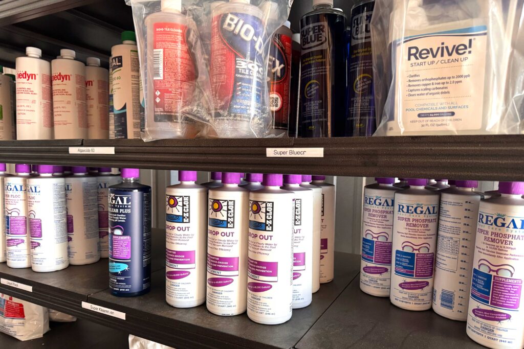 Pool chemicals and water treatment products displayed on store shelves at Paradise Pools & Plaster pool supply store in Tyler, Texas.